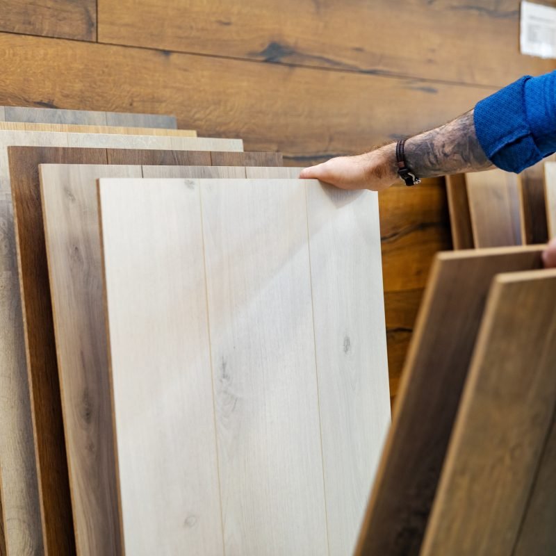 man choosing floor laminate for his home in flooring store